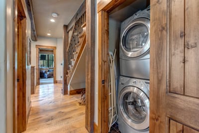 Tucked in the hall, your laundry nook includes a stacked washer/dryer and rustic wood doors for seamless convenience.