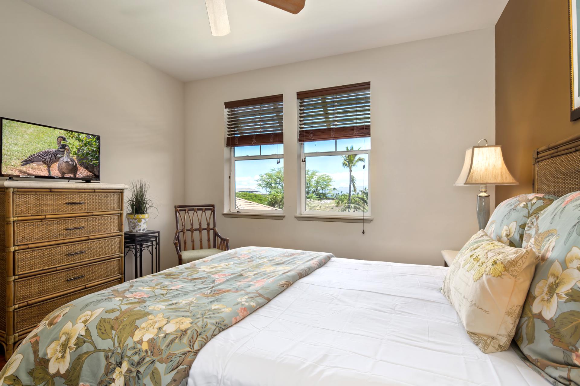 Wake up to lush tropical views in this charming guest room with cozy tones and floral accents   