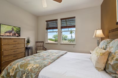 Wake up to lush tropical views in this charming guest room with cozy tones and floral accents