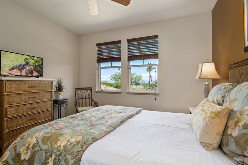 Wake up to lush tropical views in this charming guest room with cozy tones and floral accents