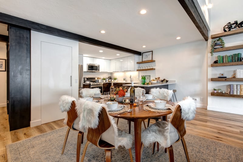 Stylish open-concept dining with wood accents and plush seating for six.