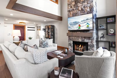 Chic mountain living with stone fireplace, plush furnishings, and après-ski ambiance.
