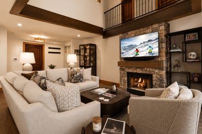 Chic mountain living with stone fireplace, plush furnishings, and après-ski ambiance.
