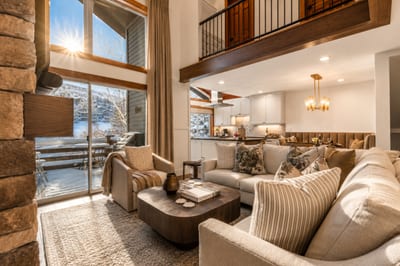 Stylish open-concept living space featuring rustic beams, cozy lounge, and sweeping views.