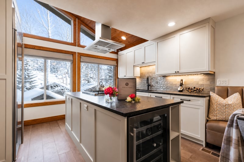 Airy kitchen with vaulted window for scenic views and cozy breakfast bench.
