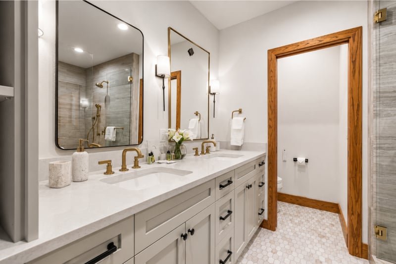 Elegant ensuite bath with dual vanity, gold fixtures, and spa-style finishes.