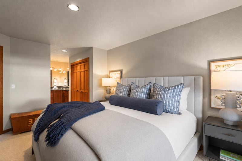 Peaceful guest room with king bed, ensuite access, and warm, ambient lighting.