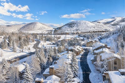 Scenic view of Deer Valley village nestled in snowy mountains under a crystal-clear winter sky.