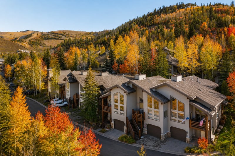Fall mountain retreat with cozy townhomes nestled among pine & aspen fall-colored trees.