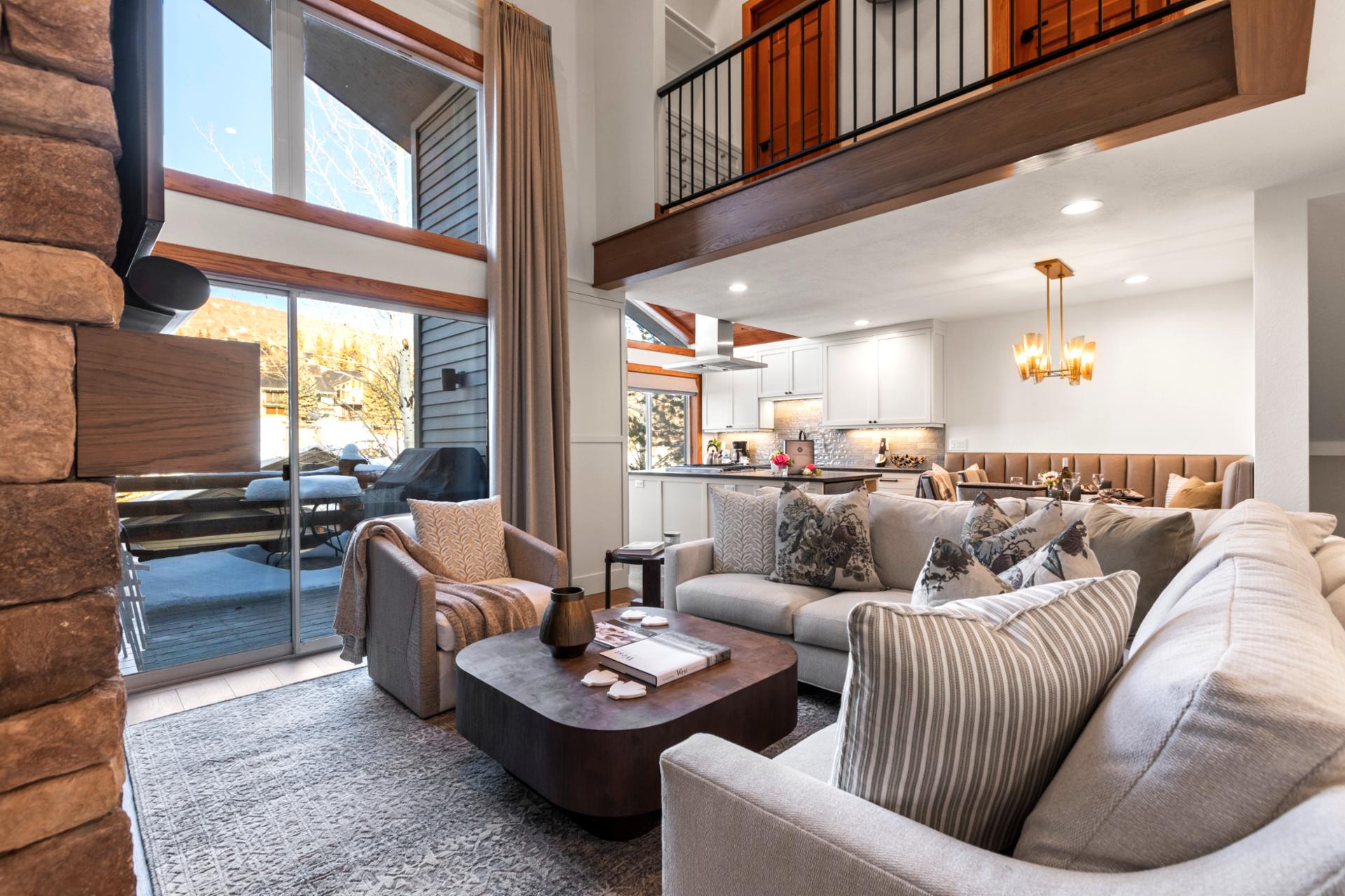 Stylish open-concept living space featuring rustic beams, cozy lounge, and sweeping views.