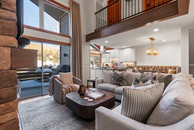 Stylish open-concept living space featuring rustic beams, cozy lounge, and sweeping views.