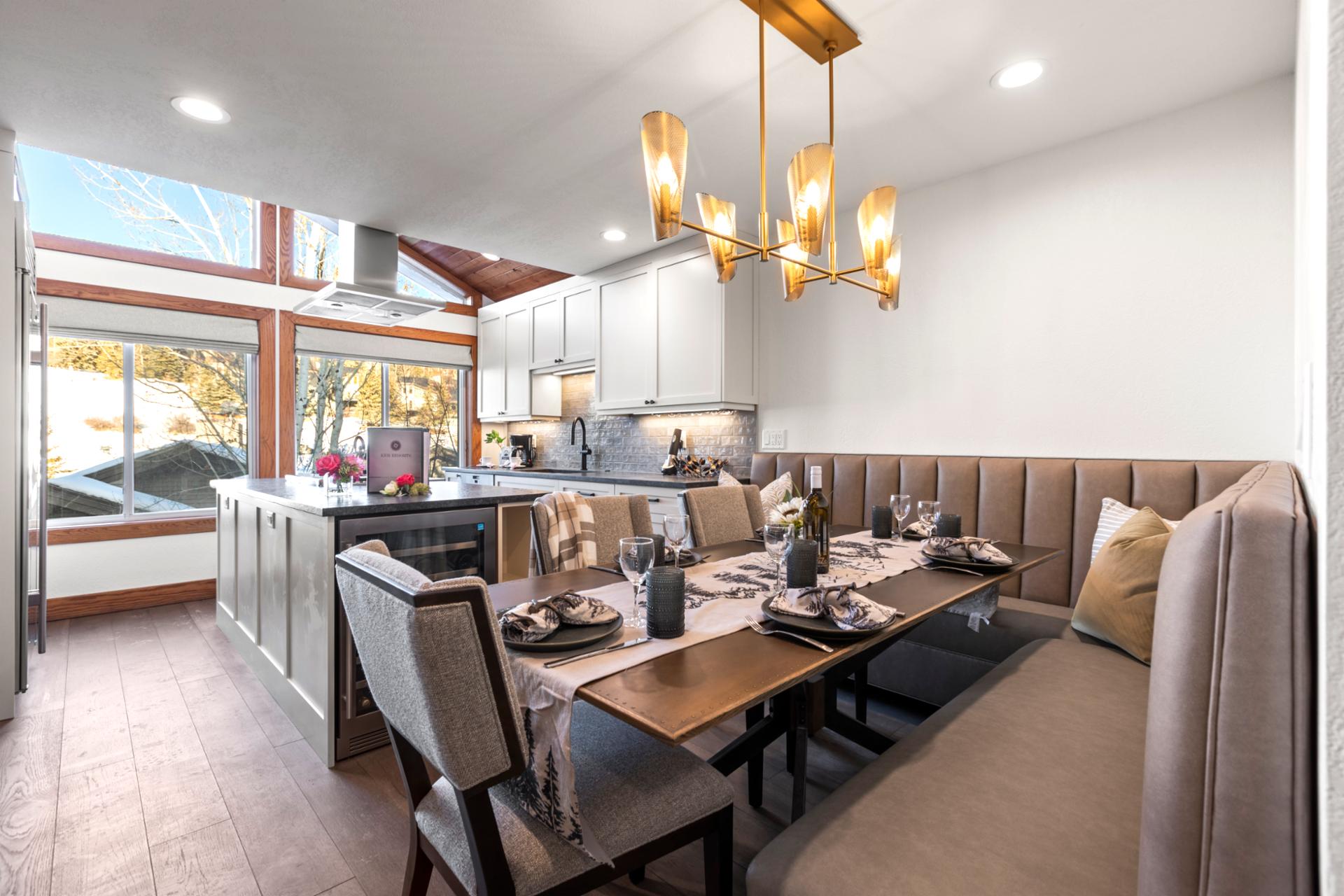Bright open-concept dining area with elegant lighting and natural flow from kitchen to living room.