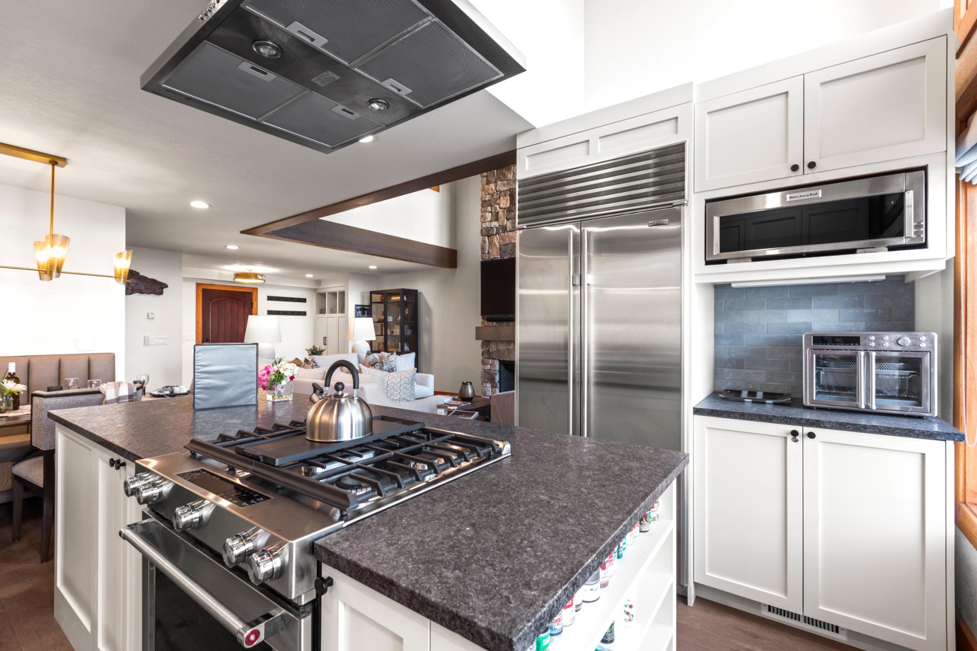Chef’s kitchen with professional stainless appliances, granite countertops, and open-concept flow.