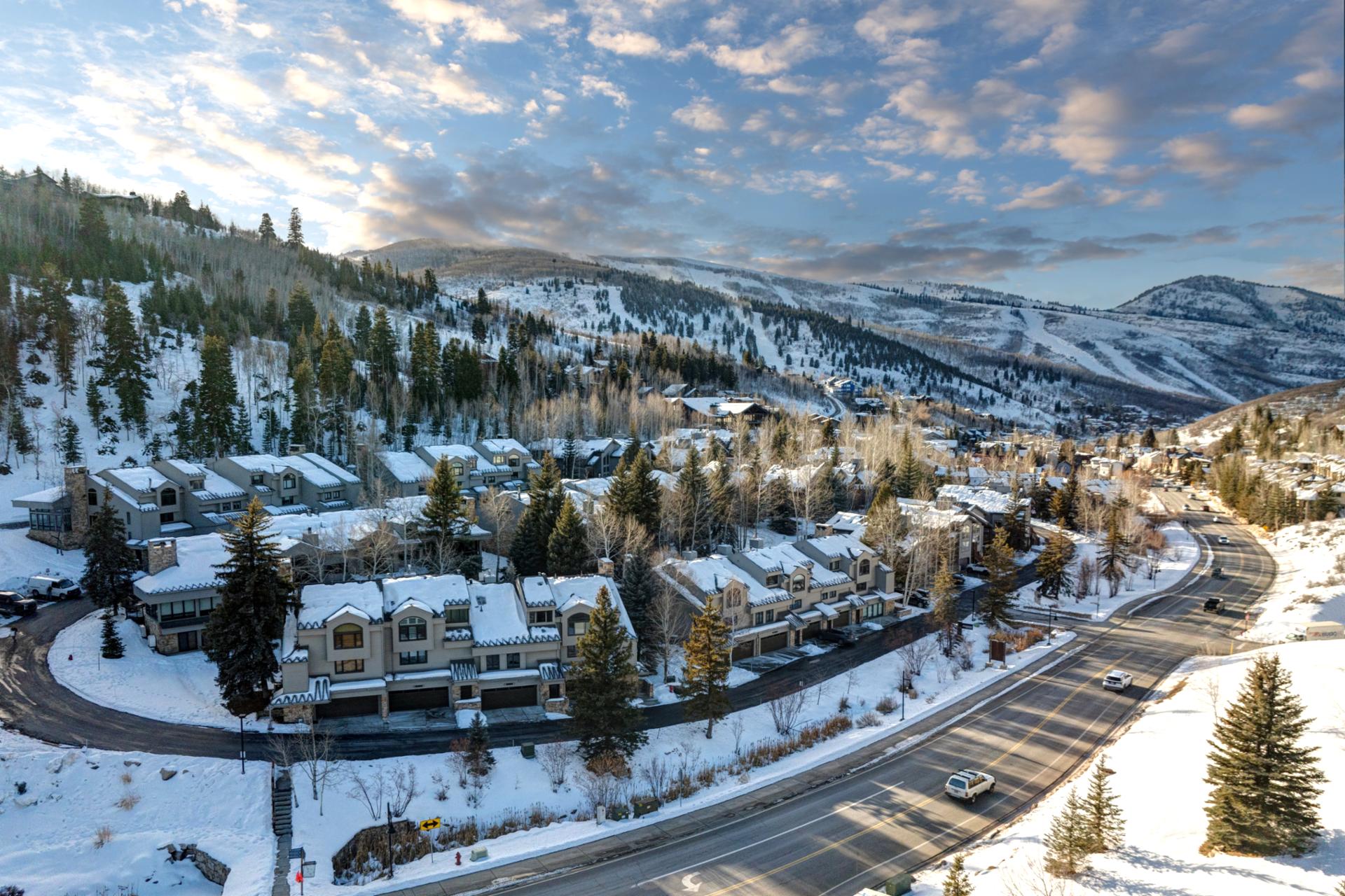Charming alpine neighborhood beneath snowy slopes and vibrant winter skies.