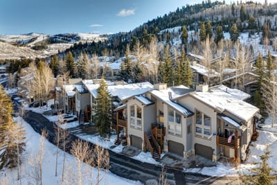 Snowy mountain retreat with cozy townhomes nestled among pine trees.