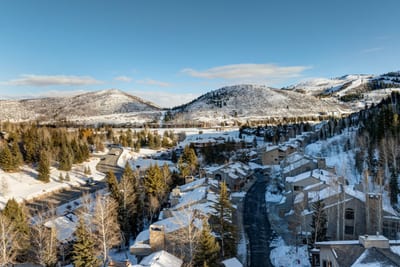 Scenic view of Deer Valley village nestled in snowy mountains under a crystal-clear winter sky.