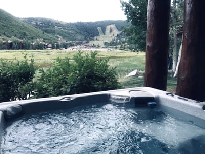 A peaceful mountain backdrop surrounds your bubbling spa, open year-round for relaxation.