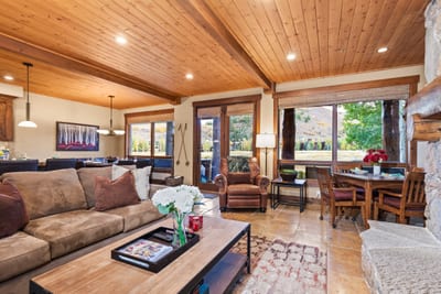 Natural light and outdoor views brighten the main living area, complete with cozy seating and rustic charm.