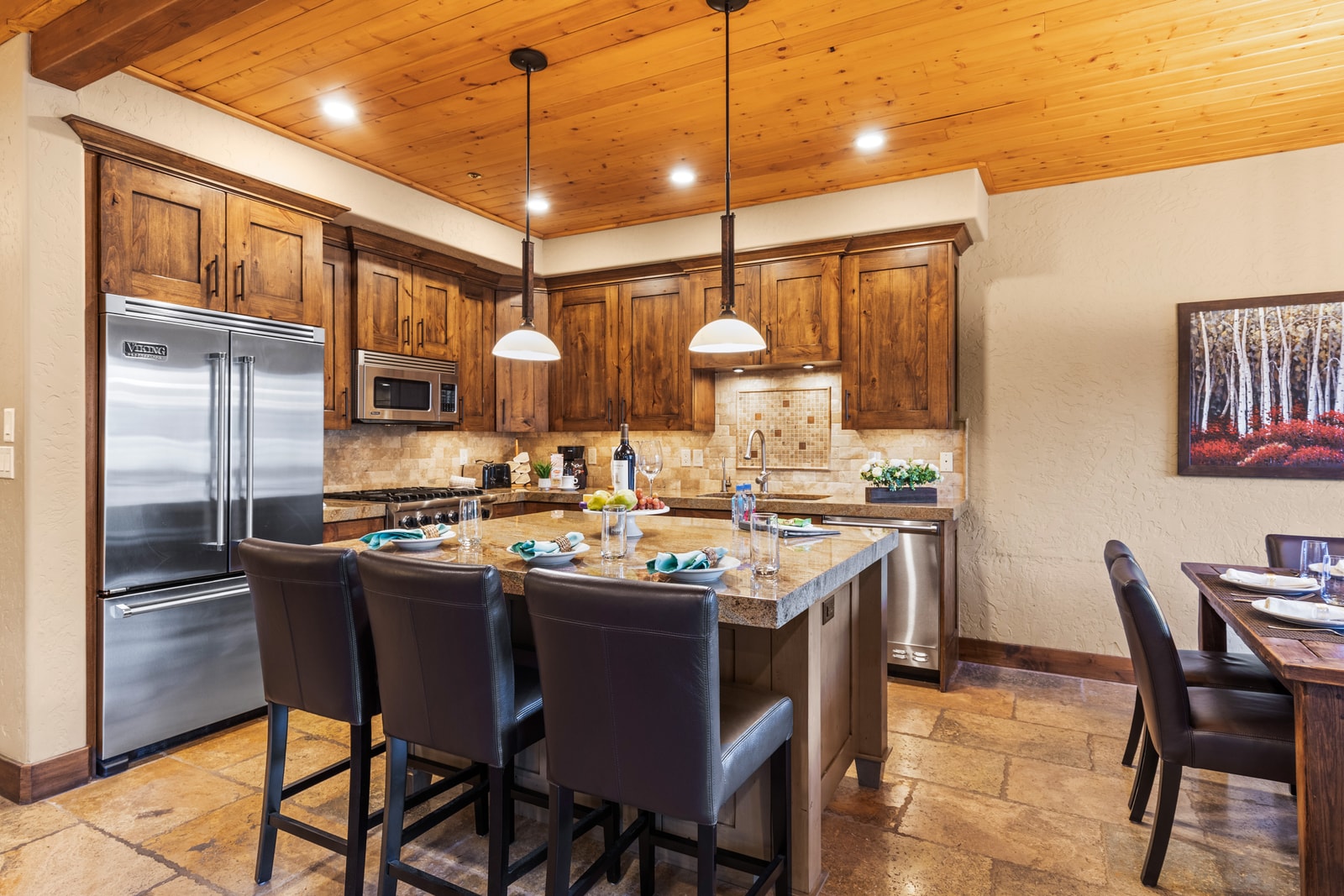 Rustic textures meet modern function in this open kitchen and dining area, perfect for group meals.