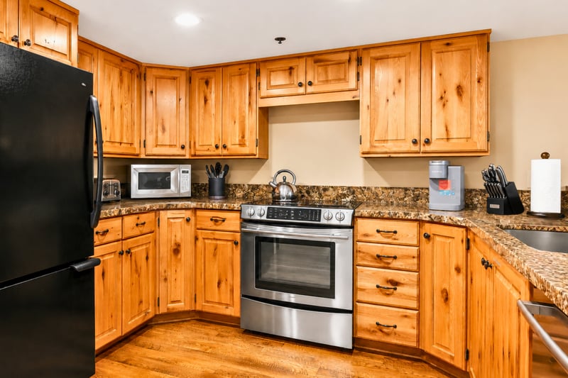Kitchen with knotty pine cabinetry, stainless range, and full-size refrigerator