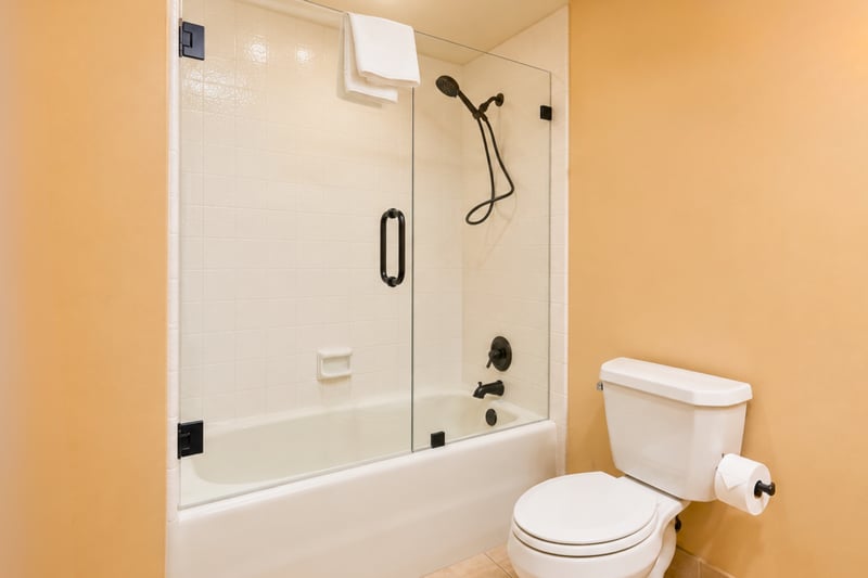 Guest bathroom with glass shower/tub combo with white subway tile
