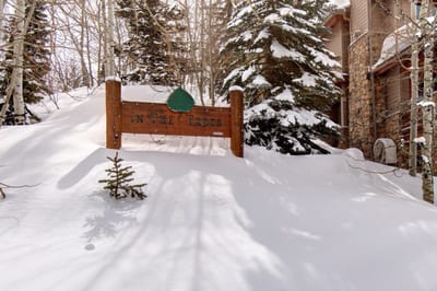 A peaceful, snow-draped setting wraps the home in quiet forest views, with direct trail access just beyond the trees.