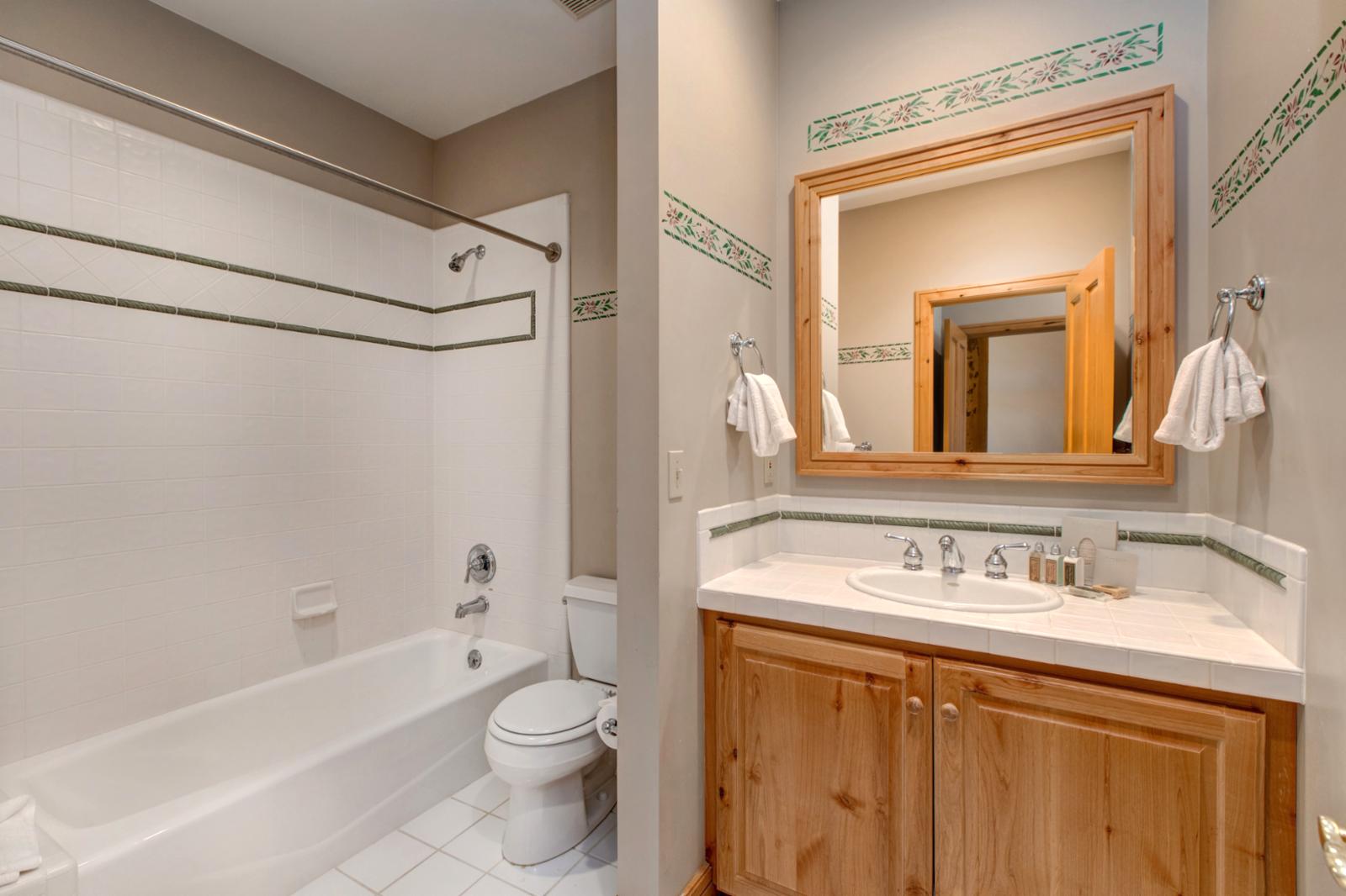 A full bath with a granite vanity and shower/tub combo makes getting ready easy for guests in the Twin bedroom.