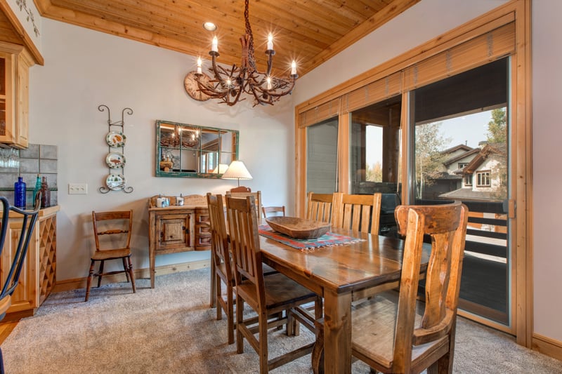 Share meals or game nights around your dining table for six, set beneath warm wood ceilings with natural light from the adjacent deck.