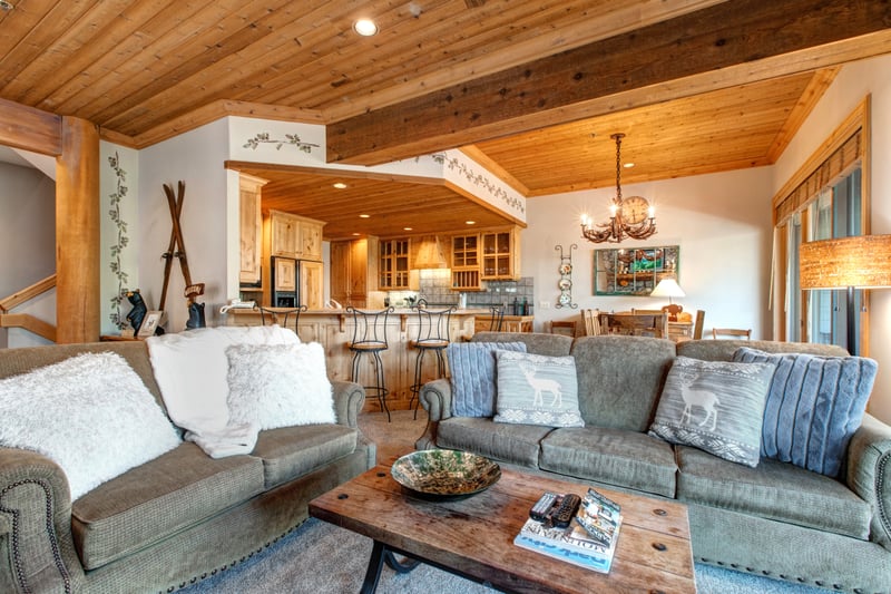 Gather in the main living area with plush seating, vaulted ceilings, and a 65" Smart TV—perfect for movie nights or snowy afternoons by the fire.