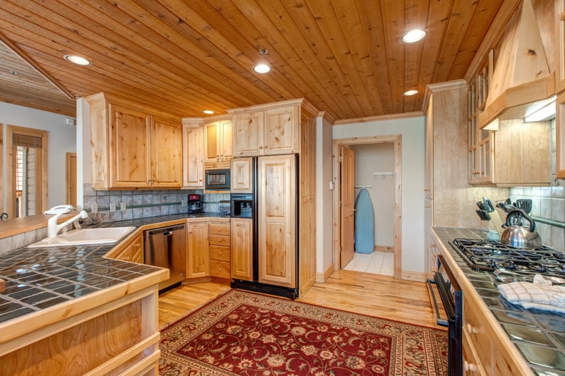 Beautiful counters, wood cabinetry, and high-end appliances give this kitchen the tools and style for a gourmet night in.
