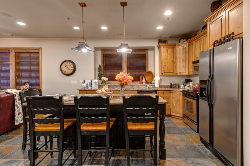Open-concept kitchen with granite island seating, gas range, and full-size stainless appliances. PPS-1416