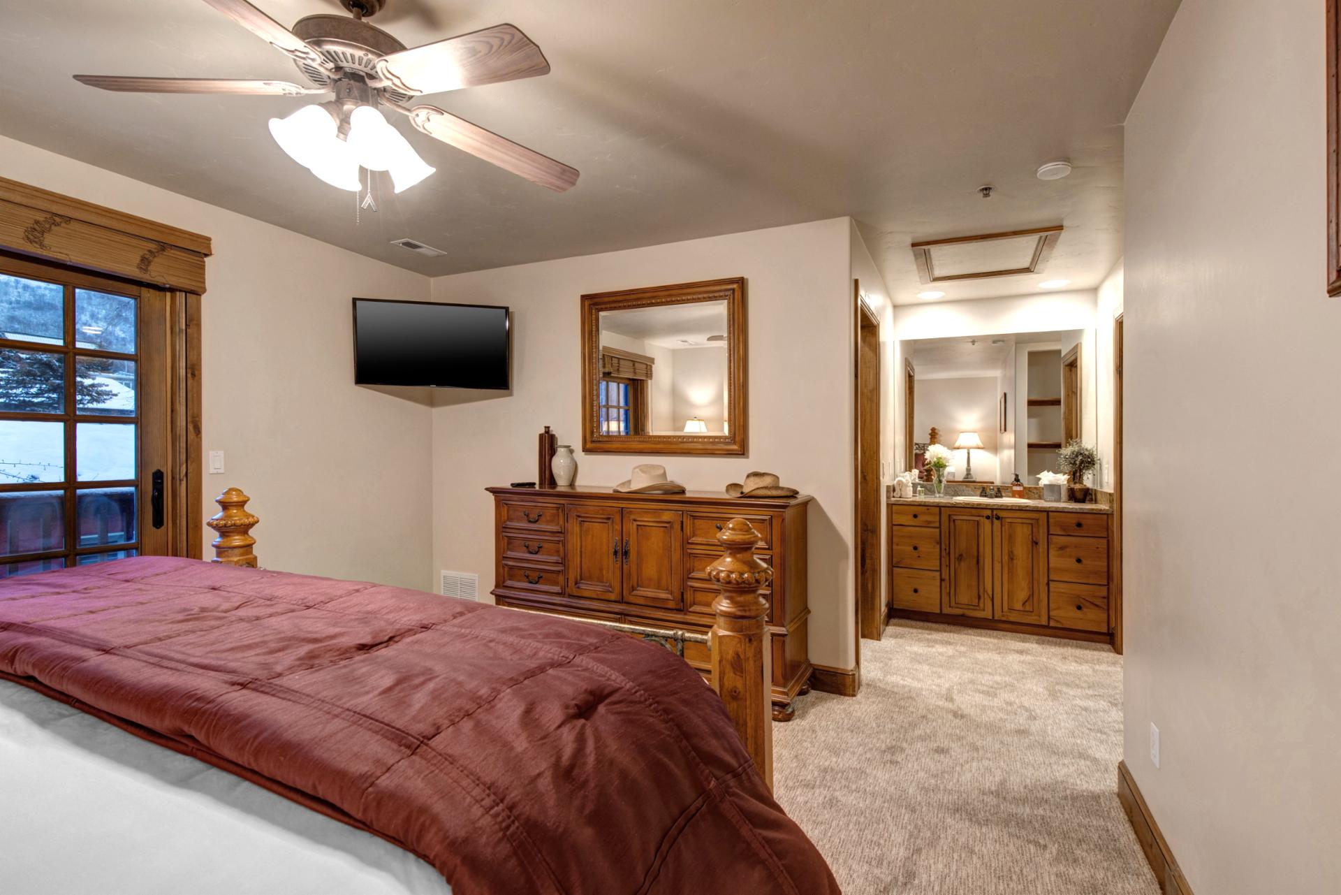 King suite includes a large dresser, ceiling fan, and access to a luxurious en suite bath.