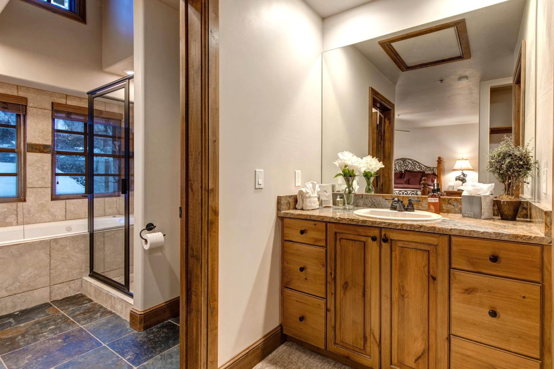 The en suite features a granite dual vanity, walk-in shower, and separate soaking tub.