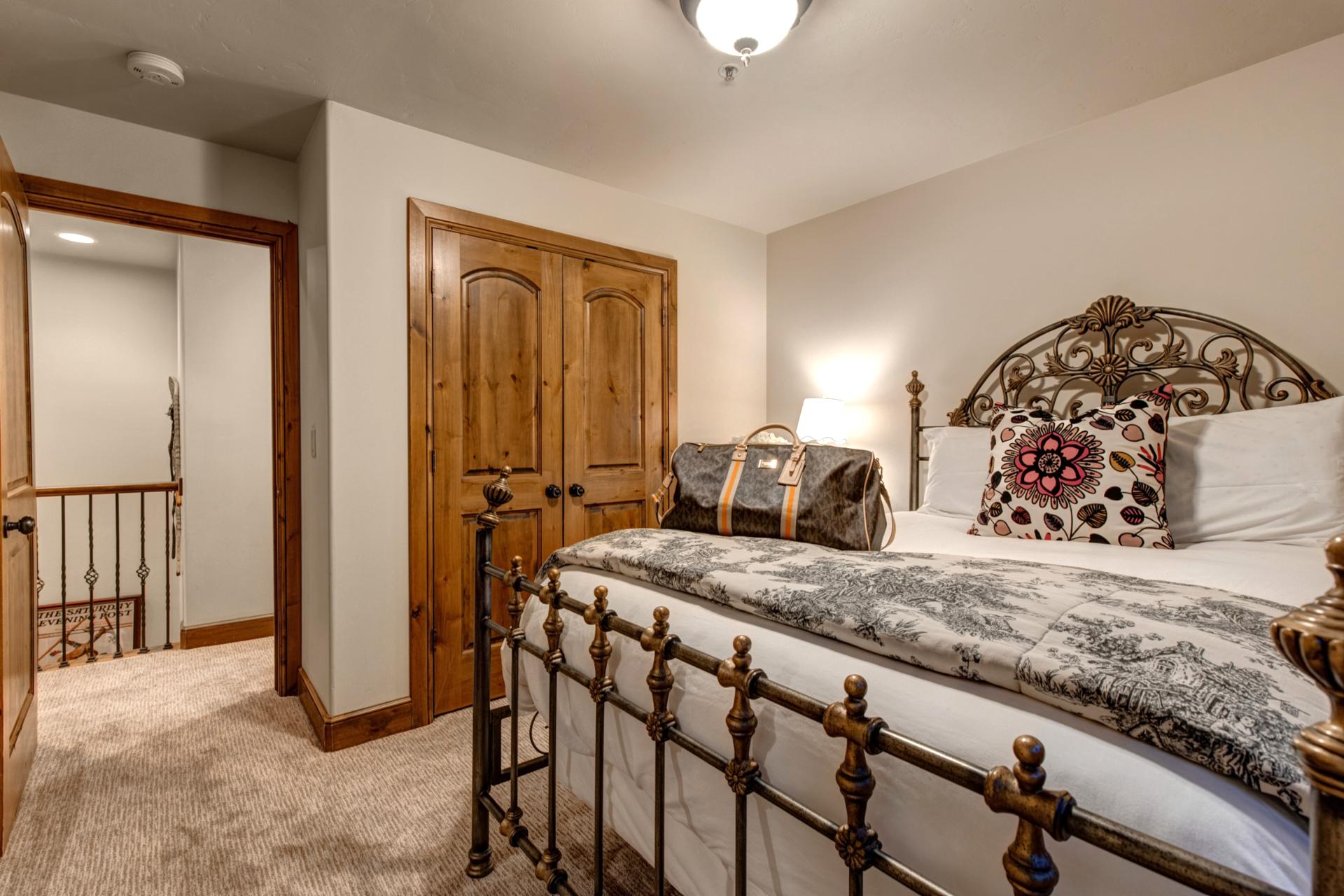 This Queen room features large windows, a mounted TV, and access to the adjoining en suite bath.