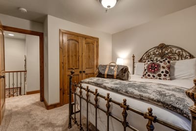 This Queen room features large windows, a mounted TV, and access to the adjoining en suite bath.