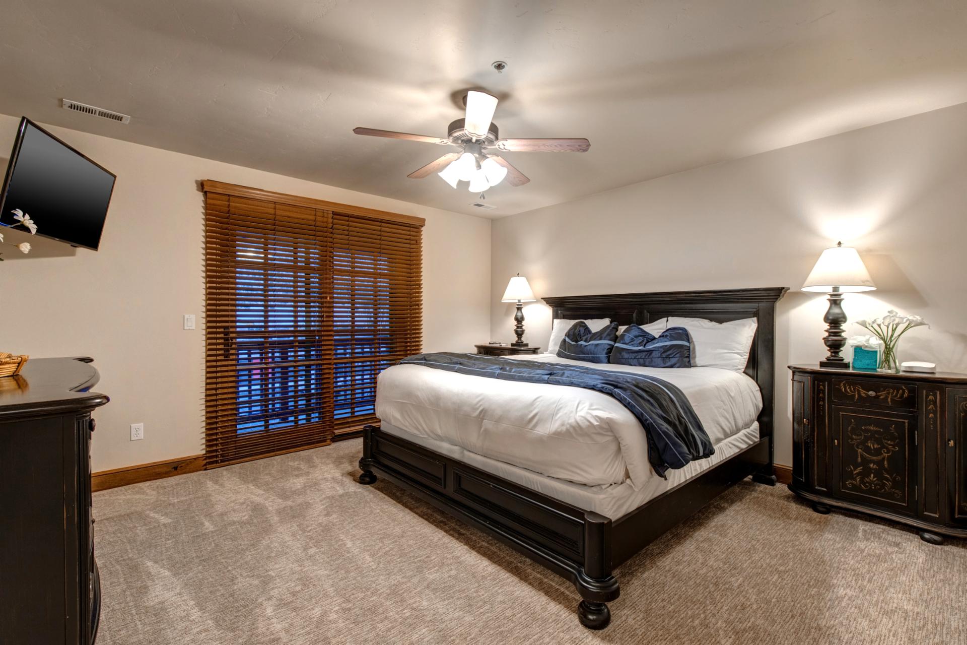 Spacious King bedroom with private balcony access, ceiling fan, and classic lodge-style furnishings.