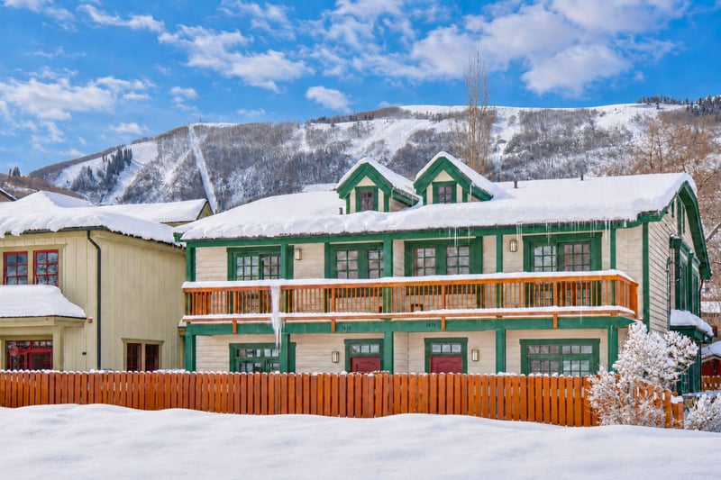 Charming duplex framed by fresh snow, wooden balconies, and a scenic mountain backdrop. PPS-1416