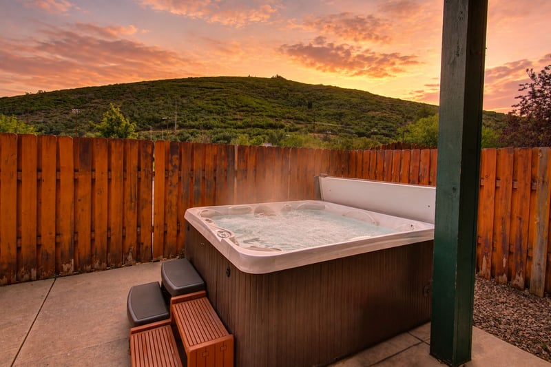 Hot tub offers privacy and comfort with wooden fencing and outdoor lighting, year round. PPS-1416