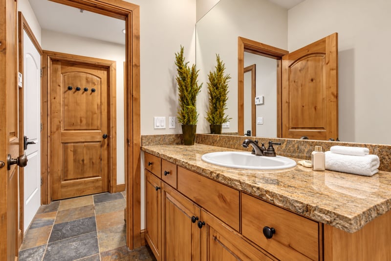 Main-level powder room includes a granite vanity and lodge-inspired wood details.