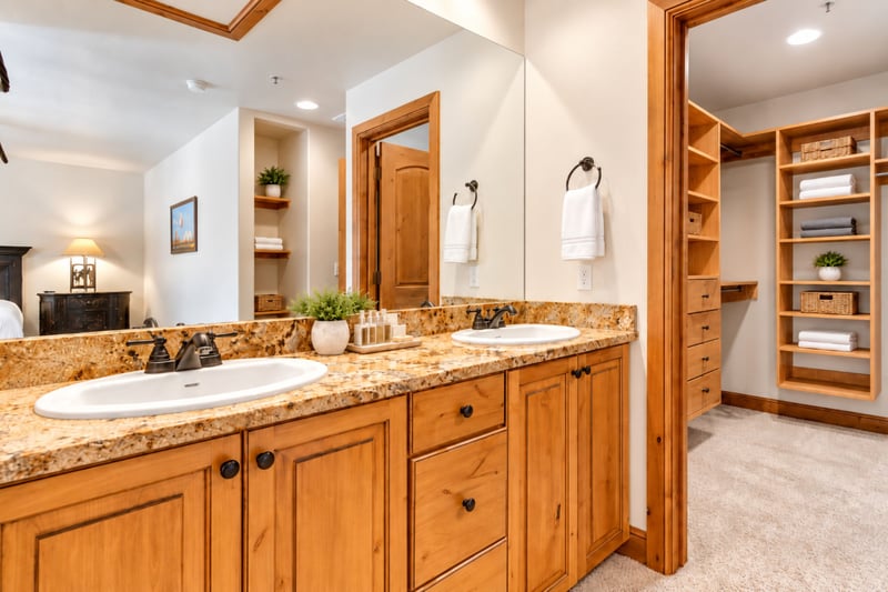 This spacious master bath includes a walk-in closet, dual vanities, and natural wood accents throughout.