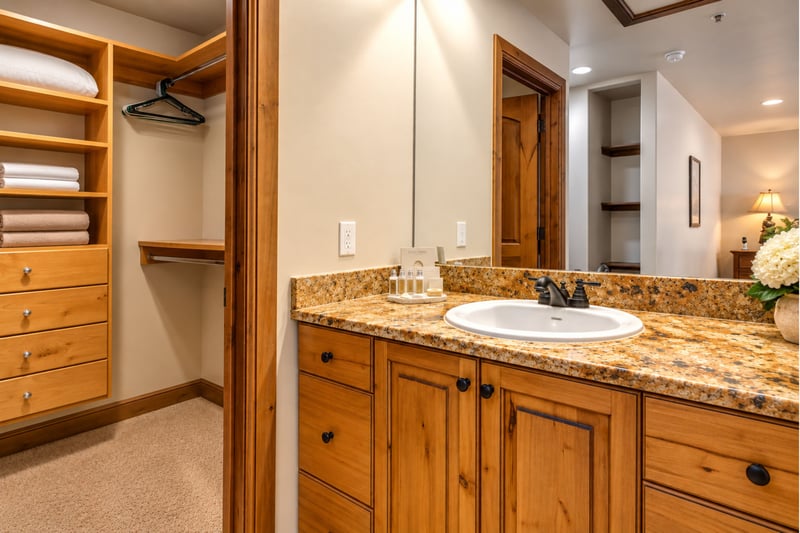 The primary ensuite offers dual granite vanities, warm wood cabinetry, and plenty of space to refresh.
