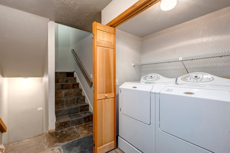 Full laundry room includes washer, dryer, and counter space for longer stays.
