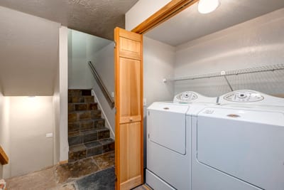 Full laundry room includes washer, dryer, and counter space for longer stays.