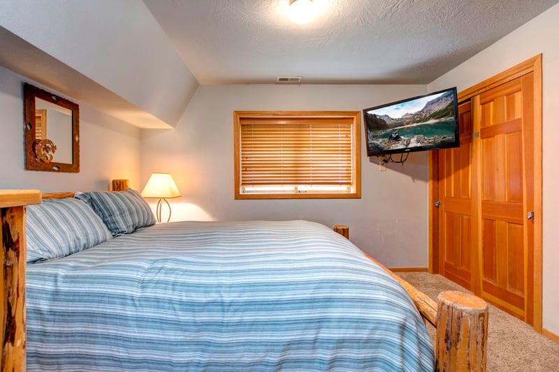 Guest Bedroom 2 includes a Queen bed, mounted Smart TV, and cozy lower-level privacy with ensuite access.