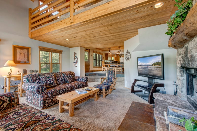 Living room includes plush seating, large windows, and a wood-burning fireplace for cozy nights in.
