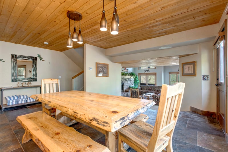 Wood-paneled ceilings and rustic finishes add charm to the dining area.
