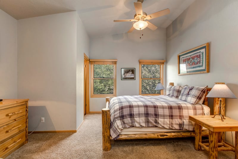Guest Bedroom 1 includes a Queen bed, natural wood furniture, and easy access to the shared hall bath.