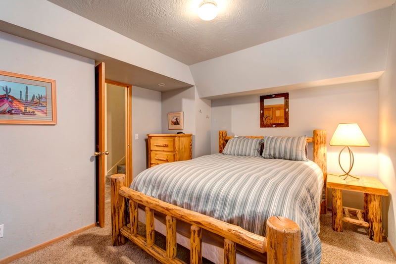Guest Bedroom 2 includes a Queen bed, wood furnishings, and private bath access on the lower level.