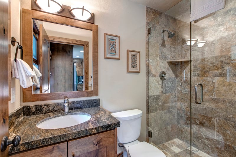 Guest Bath 4 near the kitchen includes a walk-in shower and sleek fixtures for easy access.
