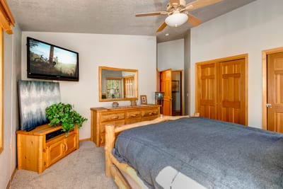 Another view of the King primary suite with mounted TV and direct access to a spa-like bath.